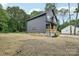 Two-story home featuring black siding, light-colored porch and driveway, and ample yard space at 401 W Charlotte Ave, Mount Holly, NC 28120