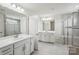 Bright bathroom with dual sinks, white cabinets, and a glass-enclosed shower at 4029 Spring Garden St, Fort Mill, SC 29715