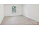 A well-lit bedroom features a large window and neutral-colored carpet at 403 W Charlotte Ave, Mount Holly, NC 28120