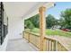 Inviting covered front porch with charming wood railing and a view of the surrounding landscape at 403 W Charlotte Ave, Mount Holly, NC 28120