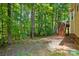 Landscape view of the wooded backyard showing the wooden deck with steps at 4612 Saxonbury Way, Charlotte, NC 28269