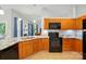 Well appointed kitchen features black appliances, granite countertops, and wood cabinets at 4612 Saxonbury Way, Charlotte, NC 28269