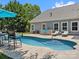Backyard oasis with a sparkling swimming pool, lounge chairs, and an umbrella, creating a relaxing retreat at 5005 Hedgebrook Ln, Waxhaw, NC 28173