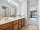 Bright bathroom with double sink vanity, wood cabinets, and tile flooring near an open doorway to a blue bedroom at 5005 Hedgebrook Ln, Waxhaw, NC 28173