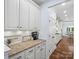Charming butler's pantry boasts a coffee station and white cabinetry with granite countertops, connecting to the dining room at 5005 Hedgebrook Ln, Waxhaw, NC 28173