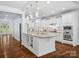 Spacious kitchen with white cabinets, a large center island, stainless steel appliances, and hardwood floors at 5005 Hedgebrook Ln, Waxhaw, NC 28173