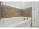 Close-up of white soaking tub with brass fixtures and tile surround at 5114 Whispy Vines Ln, Huntersville, NC 28078