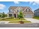 Charming two-story home featuring stone accents, a gray two-car garage, and a manicured front lawn at 5114 Whispy Vines Ln, Huntersville, NC 28078