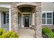 Inviting front entrance with stone archway, wreath-adorned door, and manicured landscaping at 5114 Whispy Vines Ln, Huntersville, NC 28078