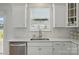 Bright kitchen sink area with stainless steel appliances, white cabinets, and ample natural light, perfect for cooking at 5114 Whispy Vines Ln, Huntersville, NC 28078