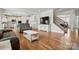Open-concept living room showcasing hardwood floors, a large TV, and a staircase at 5114 Whispy Vines Ln, Huntersville, NC 28078