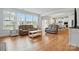 Bright living room featuring hardwood floors, large windows, and open access to the eat-in kitchen at 5114 Whispy Vines Ln, Huntersville, NC 28078