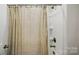 Close-up of a shower with curtain and a white shower caddy in a neutral colored bathroom at 5114 Whispy Vines Ln, Huntersville, NC 28078