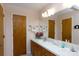 Well-lit bathroom with double sinks, wooden cabinets, and large mirror at 517 Powell St, Rock Hill, SC 29732