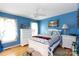 Bright bedroom with blue walls, ceiling fan, hardwood floors, and white wooden furniture set at 517 Powell St, Rock Hill, SC 29732