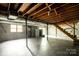 Unfinished basement featuring exposed ceiling, concrete walls, stairs, support beams, and sliding glass door at 661 Blackwelder Rd, Statesville, NC 28625