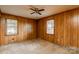 Bedroom with two windows, a ceiling fan, wood paneling, neutral carpet, and electrical outlets at 661 Blackwelder Rd, Statesville, NC 28625