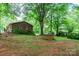 Ranch-style brick home with mature landscaping, a shed, and a grassy yard at 661 Blackwelder Rd, Statesville, NC 28625
