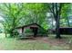 Garage with bushes around it and a bench in front with an open shed behind it at 661 Blackwelder Rd, Statesville, NC 28625