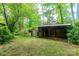 Open shed next to closed shed in wooded area of property with green grass and tree cover at 661 Blackwelder Rd, Statesville, NC 28625
