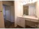 Well-lit bathroom with vanity featuring a large mirror, white cabinets, and a tiled floor at 6919 Ware Rd, Charlotte, NC 28212