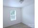 Neutral bedroom featuring carpeted floors, one window, and white walls at 6919 Ware Rd, Charlotte, NC 28212