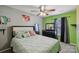 Charming bedroom featuring vibrant green walls, plush bedding, and a ceiling fan at 719 Dawn Cir, Charlotte, NC 28213