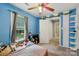 Bright bedroom featuring blue walls, carpet floors, and a window view of the yard at 719 Dawn Cir, Charlotte, NC 28213