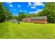 Expansive backyard featuring a lush lawn, play area and brick chimney, perfect for outdoor activities at 815 Lakeside Cir, Lancaster, SC 29720