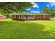 Charming red brick home with a welcoming front porch and large, well-manicured lawn at 815 Lakeside Cir, Lancaster, SC 29720