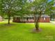 Quaint brick house with a covered front porch and a sprawling green lawn at 815 Lakeside Cir, Lancaster, SC 29720