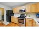 Well-equipped kitchen with stainless steel appliances, wood cabinets, and laminate floors at 820 Settlement St, Clover, SC 29710