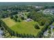 Aerial view of a home featuring a pool and acreage with mature trees and landscaping at 8698 Rocky River Rd, Harrisburg, NC 28075