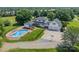 A sprawling property featuring a pool, manicured lawns, a two-story home, detached garage, and extensive fencing at 8698 Rocky River Rd, Harrisburg, NC 28075