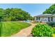 Lush backyard showcasing a pool, well-manicured lawn, a brick walkway and a charming home at 8698 Rocky River Rd, Harrisburg, NC 28075