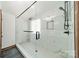 Modern bathroom featuring glass shower enclosure with white marble style tiling and black hardware at 8698 Rocky River Rd, Harrisburg, NC 28075