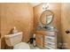 Cozy half-bathroom with neutral colors and a round mirror at 8698 Rocky River Rd, Harrisburg, NC 28075