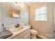 Bathroom with toilet, vanity with mirror and sink and window at 8698 Rocky River Rd, Harrisburg, NC 28075