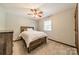 Neutral bedroom featuring a wood bed frame, ceiling fan, and natural light at 8698 Rocky River Rd, Harrisburg, NC 28075