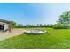 Exterior view showcasing an inviting fire pit surrounded by lush green space, perfect for outdoor gatherings and relaxation at 8698 Rocky River Rd, Harrisburg, NC 28075