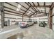 Spacious garage with a car, lawn mower, utility vehicle, large doors, and storage shelving, perfect for workshop enthusiasts at 8698 Rocky River Rd, Harrisburg, NC 28075