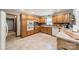 Well-lit kitchen with oak cabinets, white appliances, and ample counter space for culinary enthusiasts at 8698 Rocky River Rd, Harrisburg, NC 28075