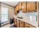 Functional laundry room featuring wood cabinets, ample counter space and a window at 8698 Rocky River Rd, Harrisburg, NC 28075