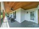 Relaxing porch with gray painted floor and rocking chairs, offering a serene outdoor space at 8698 Rocky River Rd, Harrisburg, NC 28075
