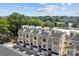 Aerial view of modern townhomes featuring private garages, brick facades, and rooftop terraces in a leafy area at 919 Cityscape Dr, Charlotte, NC 28205