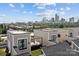 Stunning aerial view of modern townhomes with rooftop patio and Charlotte skyline backdrop under a bright, cloudy sky at 919 Cityscape Dr, Charlotte, NC 28205