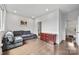 Spacious living room with hardwood floors, gray sectional sofa, accent chest, and access to additional rooms at 919 Cityscape Dr, Charlotte, NC 28205