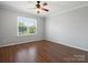 Neutral bedroom featuring hardwood floors, ceiling fan, and sunny window with view at 9404 S Vicksburg Park Ct, Charlotte, NC 28210