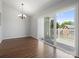 Bright dining room with hardwood floors and sliding doors to the patio, chandelier, and outdoor view at 9404 S Vicksburg Park Ct, Charlotte, NC 28210