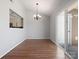 Bright dining room with hardwood floors and sliding doors to the outdoor space, chandelier, and half-wall to kitchen at 9404 S Vicksburg Park Ct, Charlotte, NC 28210